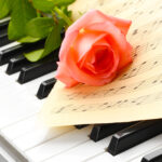 ピアノの鍵盤と楽譜、バラの写真
